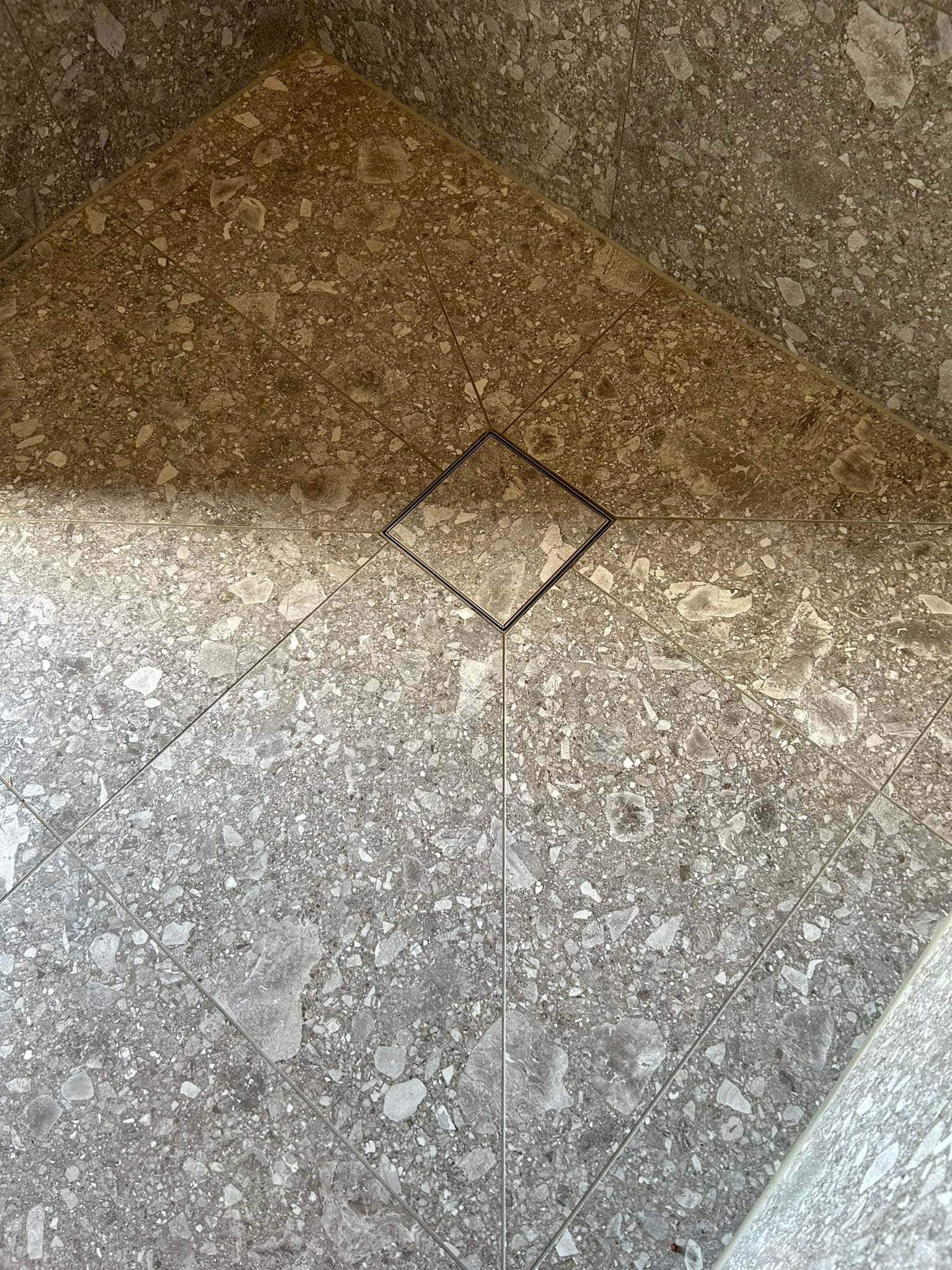 Detaljbild på golvbrunn i duschutrymme.