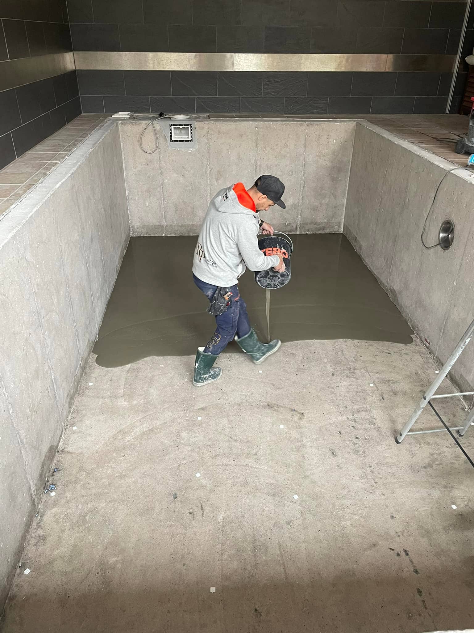 Plattsättaren arbetar med förarbetet inför att sätta plattor i poolen.