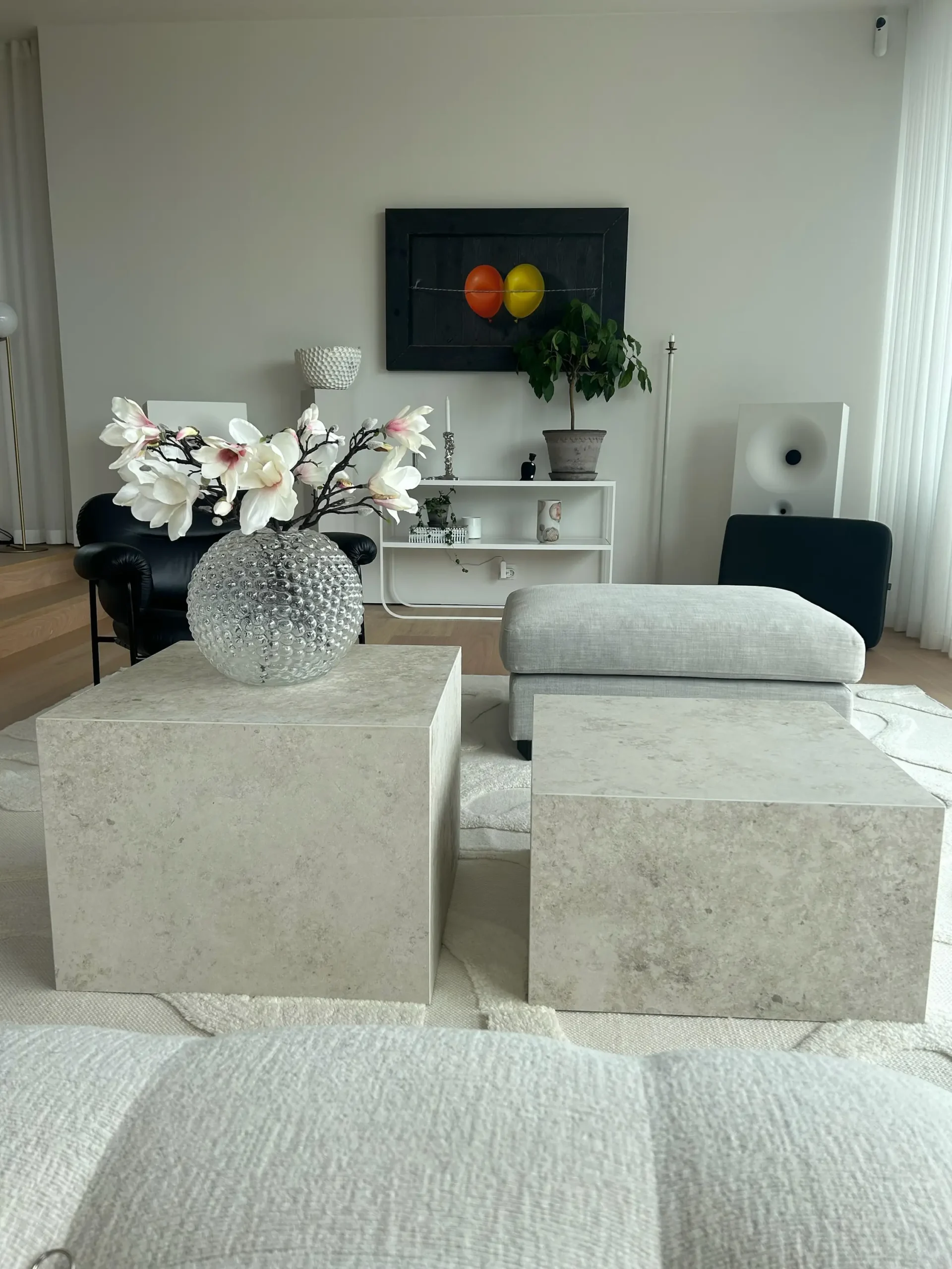 Två moderna soffbord i ljusgrå granitkeramik. Borden är kubformade och står bredvid varandra. Bordet till vänster är högre än det andra bordet.